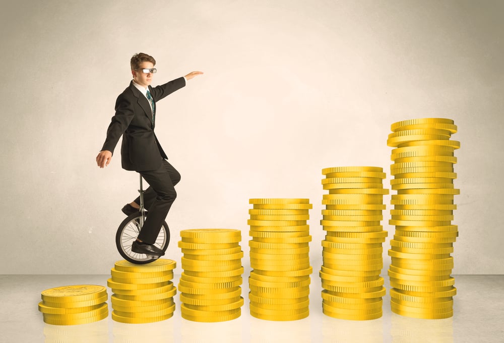 Business man riding monocycle up on coin graph concept on background